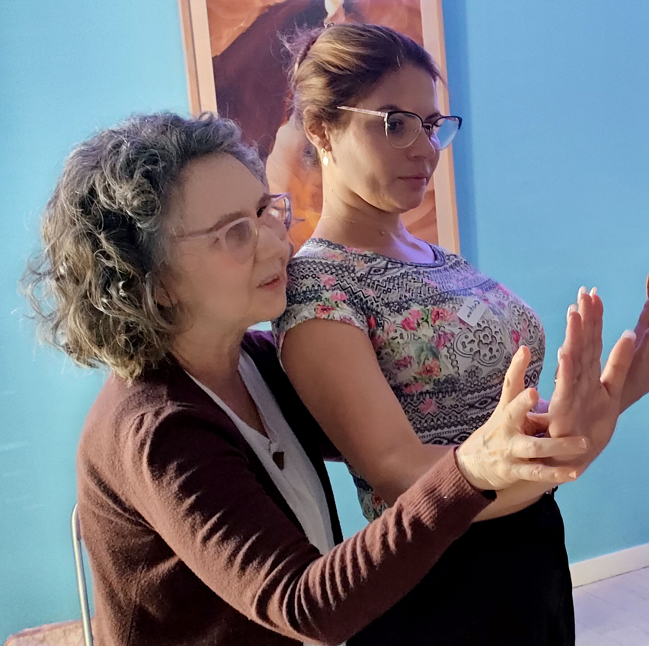 Maestra de Reiki corrigiendo la postura de una alumna durante el Curso de Terapeuta de Reiki Profesional en Madrid