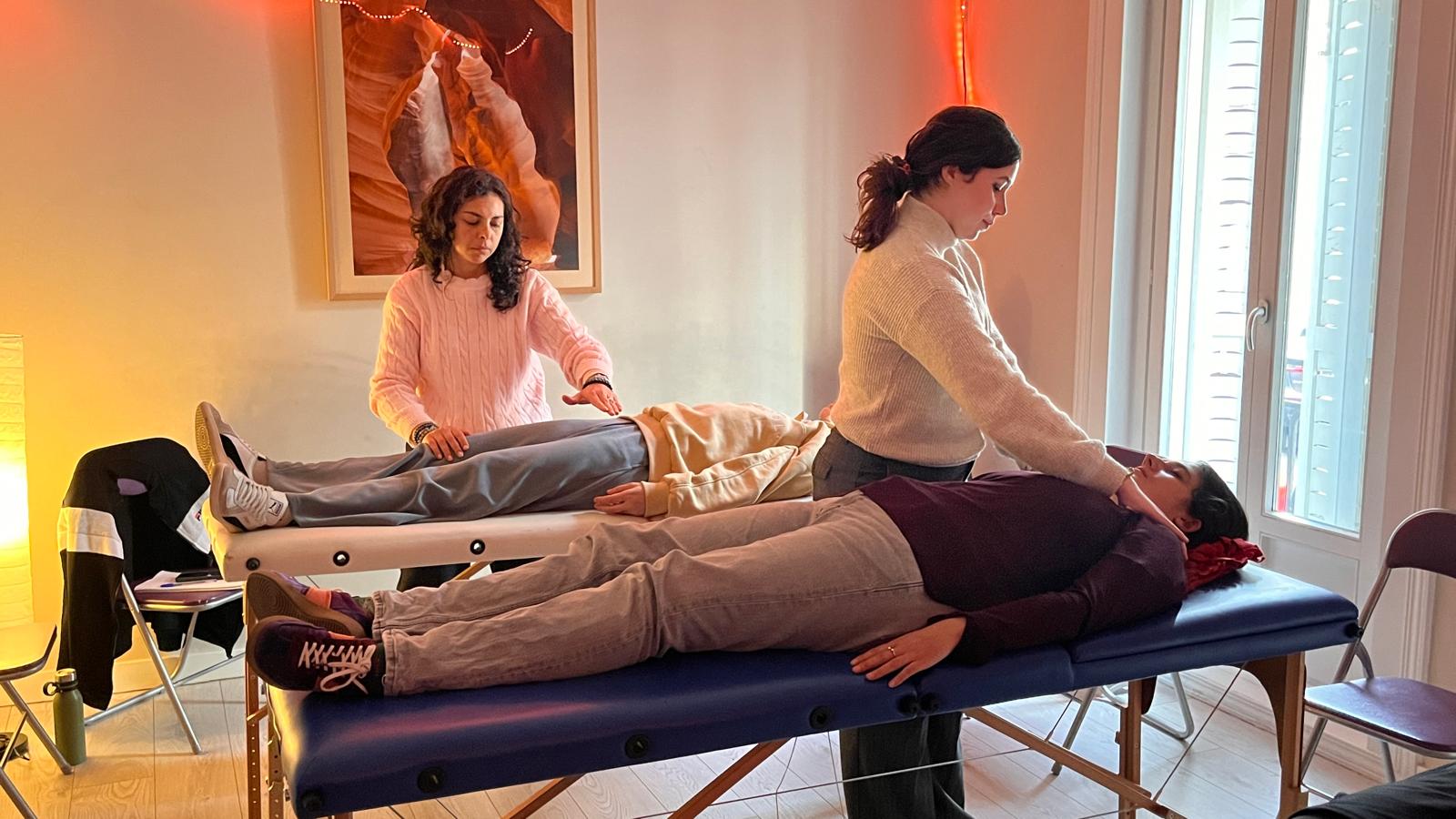 Alumnos de un curso de Reiki profesional realizando tratamientos de Reiki a pacientes